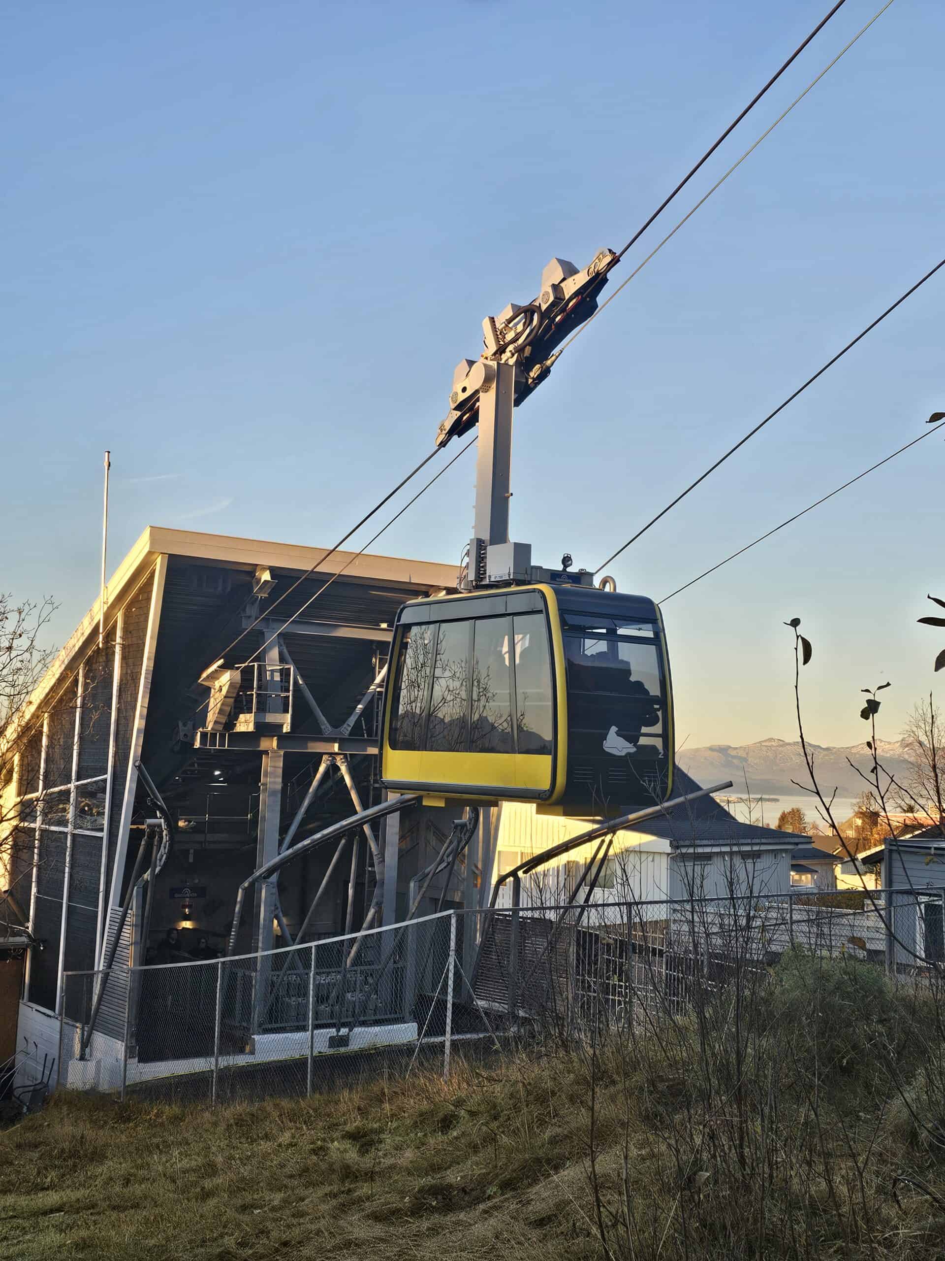 Tromsø cable car ascending with scenic Arctic landscape in background.